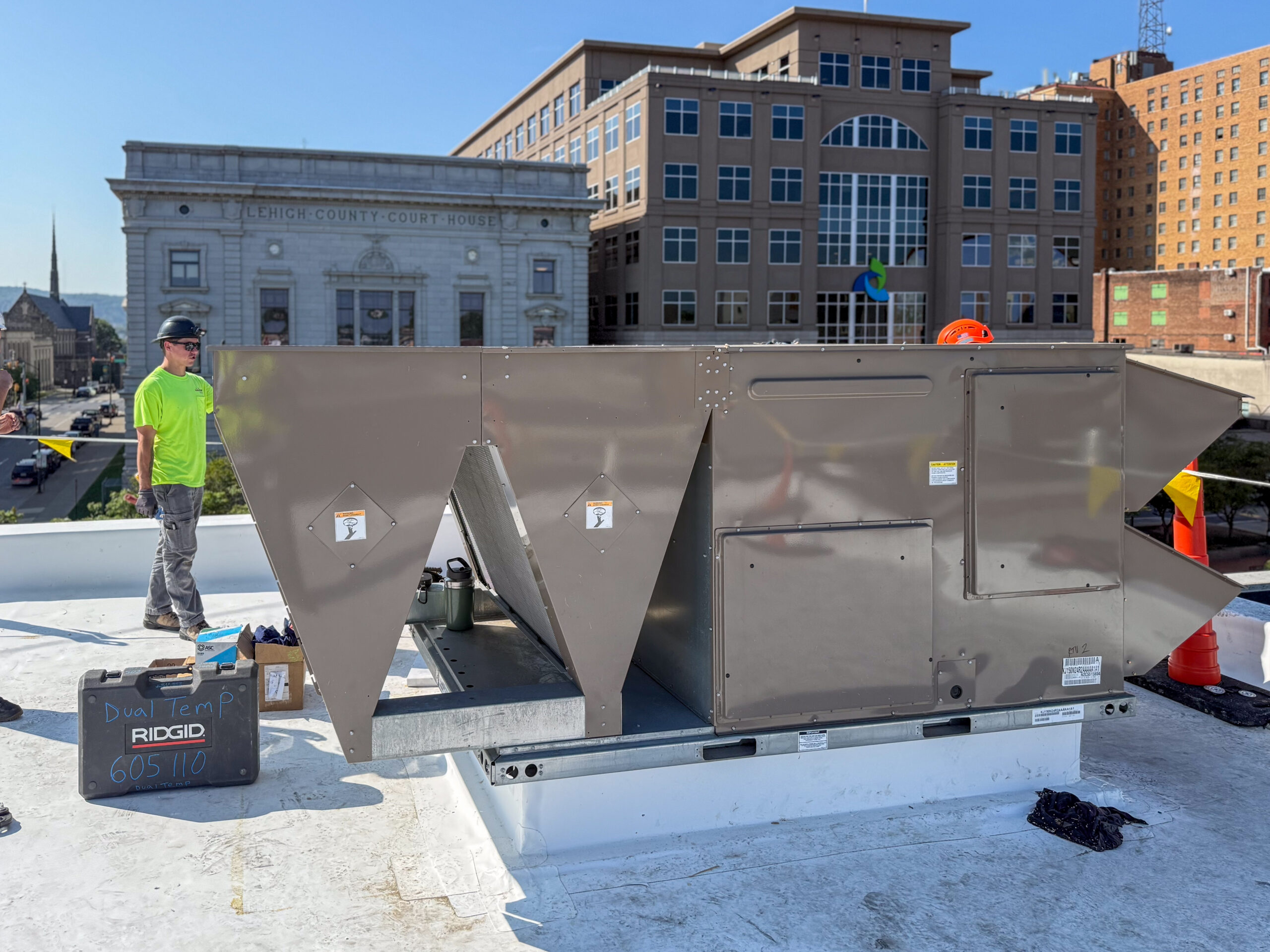 Rooftop HVAC unit installation with worker